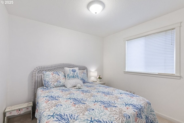 carpeted bedroom featuring a textured ceiling and baseboards