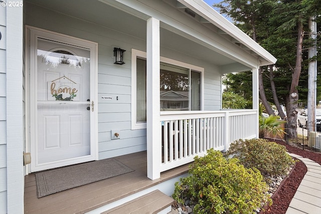 property entrance with covered porch and brick siding