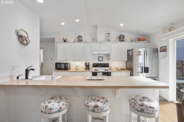 kitchen featuring electric stove, stainless steel fridge with ice dispenser, under cabinet range hood, black microwave, and a sink