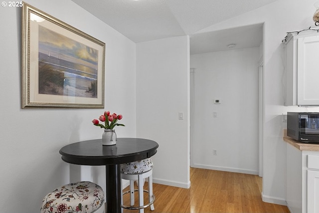 dining area featuring light wood-style flooring and baseboards