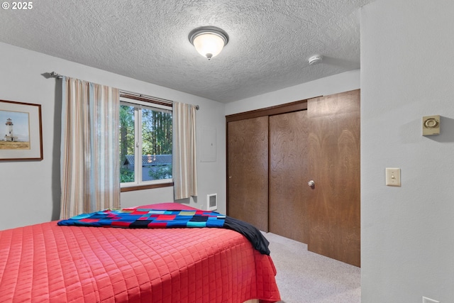 bedroom featuring a closet, a textured ceiling, and carpet