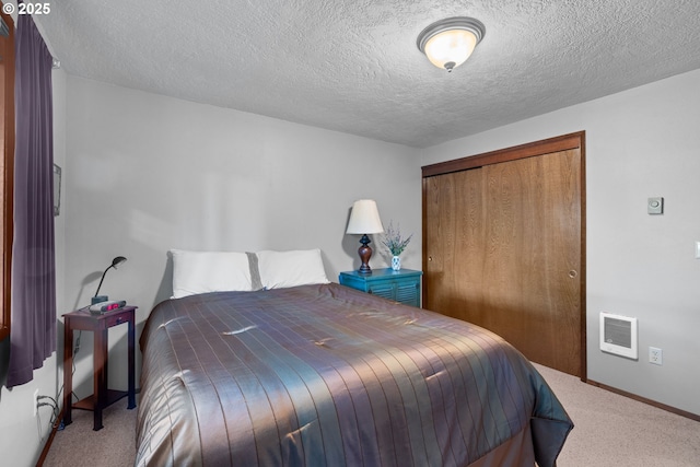 bedroom featuring light carpet, a closet, and a textured ceiling