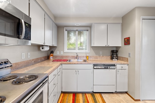 kitchen with appliances with stainless steel finishes, sink, and white cabinets