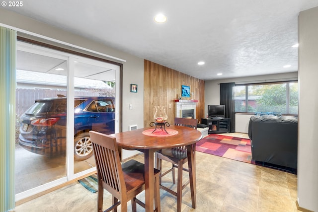 dining area with a textured ceiling and wood walls