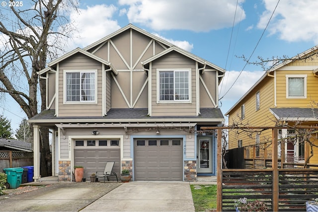 tudor house featuring stone siding, concrete driveway, an attached garage, and fence