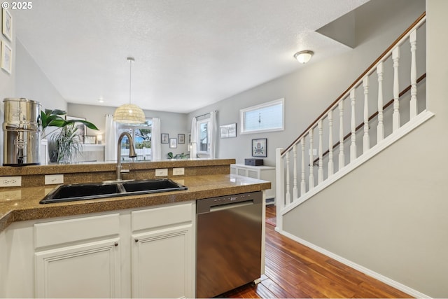 kitchen featuring dark wood finished floors, decorative light fixtures, tile countertops, dishwasher, and a sink