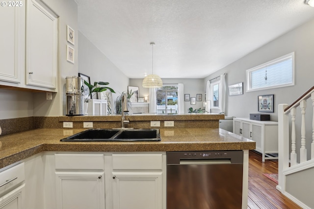 kitchen featuring a sink, dark wood finished floors, tile countertops, a peninsula, and dishwasher