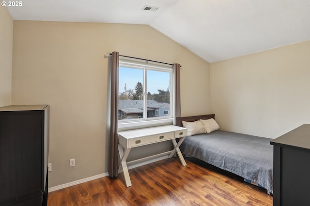 bedroom featuring vaulted ceiling, visible vents, baseboards, and wood finished floors