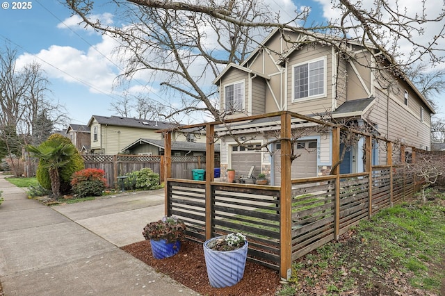 exterior space featuring a fenced front yard, stone siding, and driveway