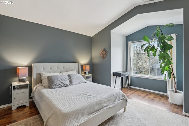 bedroom with baseboards, dark wood-type flooring, and vaulted ceiling