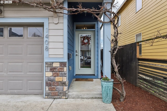 doorway to property featuring fence and stone siding