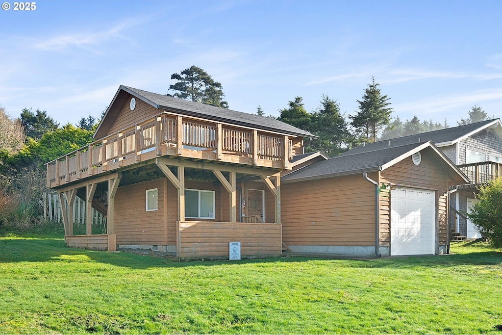 back of property featuring a lawn, a garage, and a wooden deck