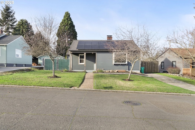 view of front facade featuring solar panels and a front lawn