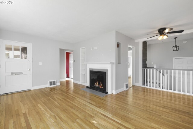 unfurnished living room featuring a tile fireplace and light wood-type flooring