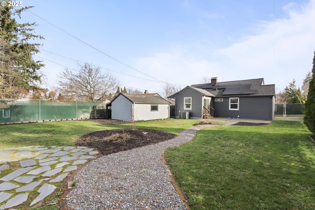 rear view of house featuring solar panels and central AC