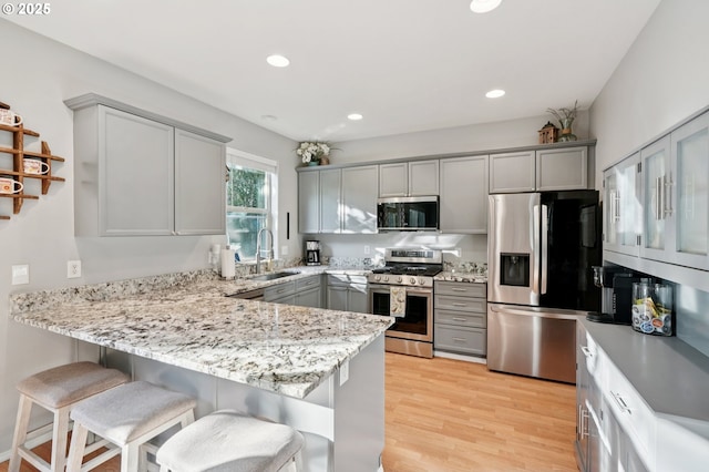 2149 SE Williams Dr, Gresham, OR 97080 - kitchen featuring appliances with stainless steel finishes, gray cabinets, a sink, a peninsula, and a breakfast bar