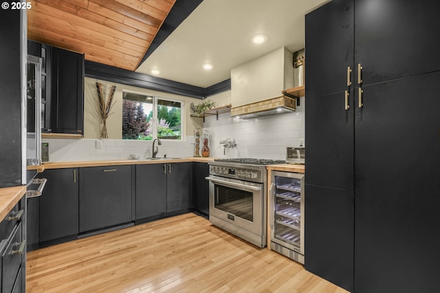 kitchen with a sink, dark cabinetry, high end stainless steel range, and open shelves
