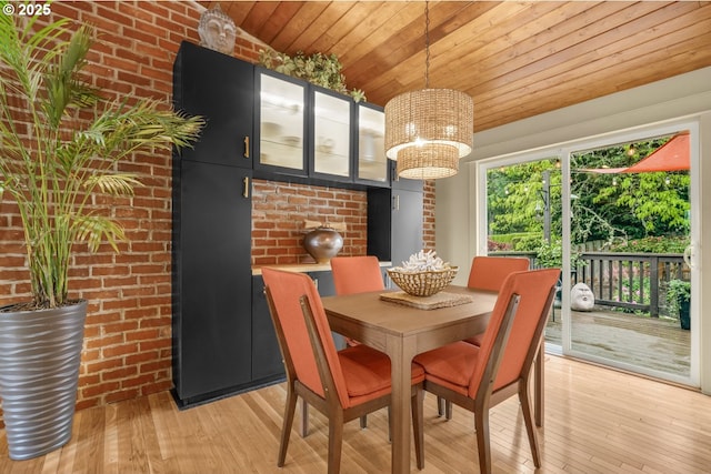 dining space with wood ceiling, brick wall, a chandelier, and light wood-style flooring