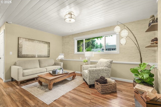 living room with baseboards, wood ceiling, and wood finished floors