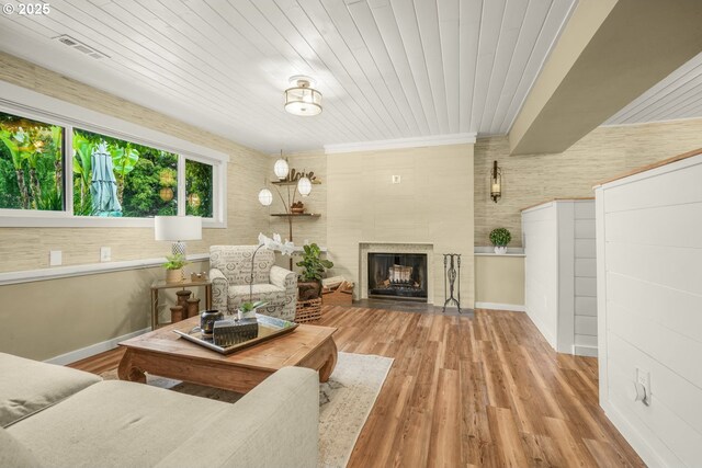 living room featuring visible vents, baseboards, wood finished floors, and a fireplace