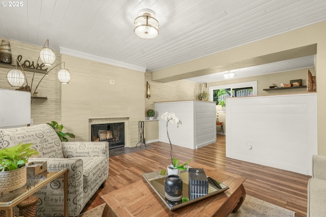 living area featuring a high end fireplace, wood finished floors, and ornamental molding