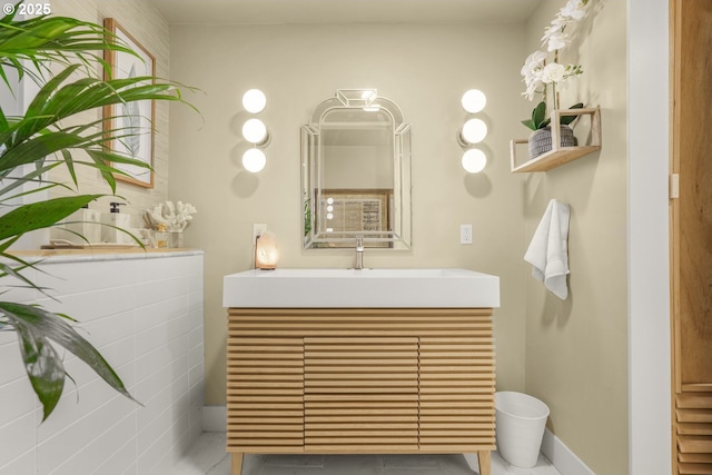 bathroom featuring vanity, baseboards, and tile patterned floors