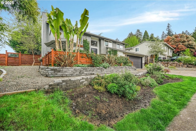 view of front of property featuring an attached garage and fence