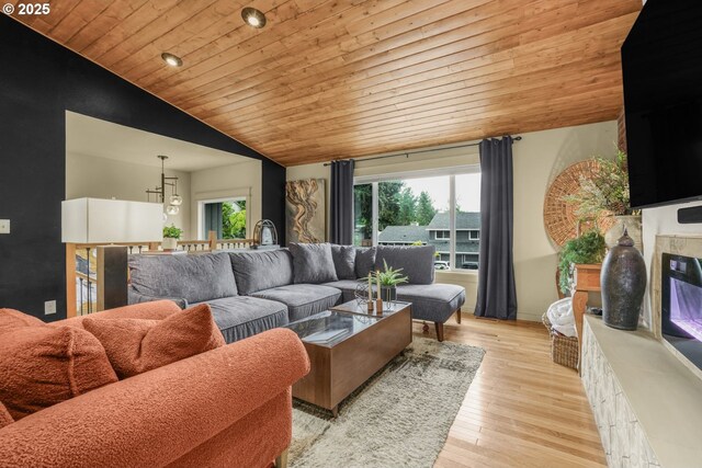 living room featuring a wealth of natural light, light wood-style floors, vaulted ceiling, and wooden ceiling