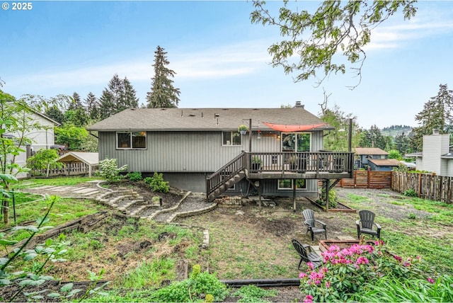 rear view of house featuring a deck, fence, stairs, and roof with shingles