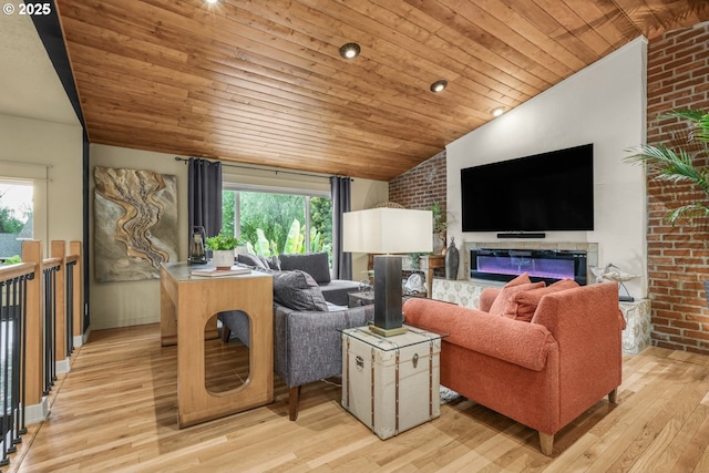 living area with a glass covered fireplace, brick wall, light wood-type flooring, wooden ceiling, and vaulted ceiling