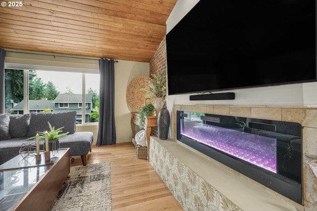 living area with wood finished floors, wood ceiling, lofted ceiling, and a tile fireplace