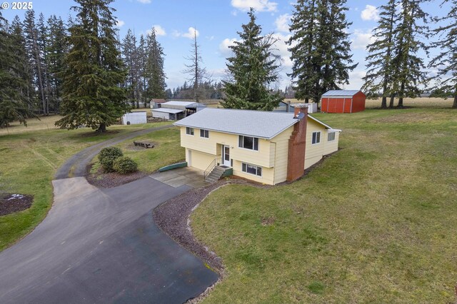 split foyer home with a garage and a front lawn