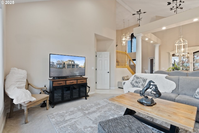 living area featuring decorative columns, stairway, a high ceiling, carpet floors, and a chandelier