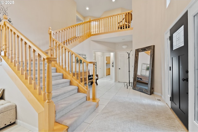 stairs featuring a high ceiling, recessed lighting, tile patterned flooring, and baseboards