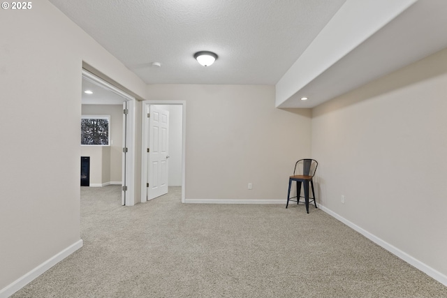 interior space with carpet flooring, a textured ceiling, and baseboards