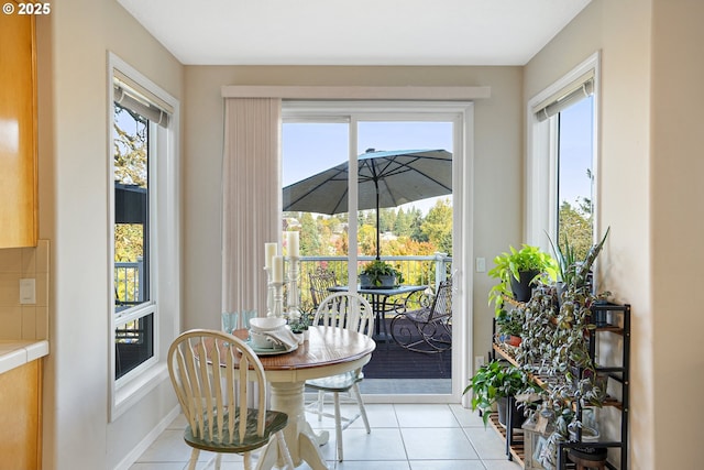 dining space featuring light tile patterned floors and baseboards