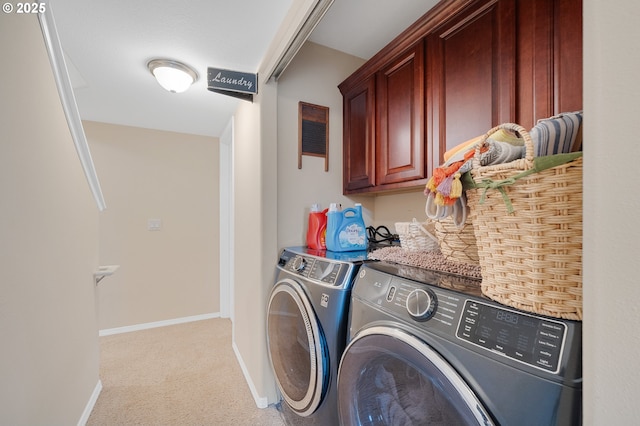 laundry area featuring cabinets, washer and dryer, and light colored carpet