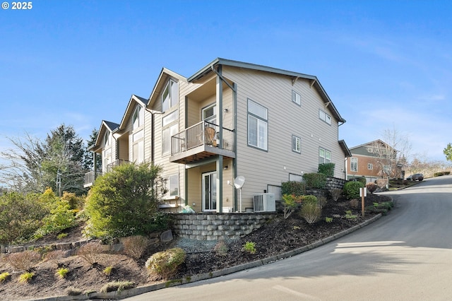 view of home's exterior with a balcony and cooling unit