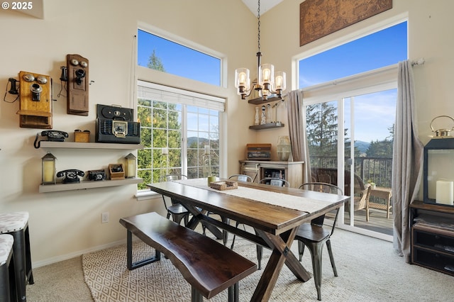 dining area with a notable chandelier, light colored carpet, and a high ceiling