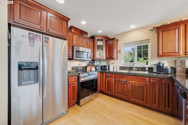 kitchen featuring appliances with stainless steel finishes, sink, and light hardwood / wood-style flooring