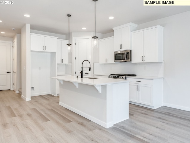 846 NW 178th Way, Ridgefield, WA 98642 - kitchen with stainless steel microwave, range, light wood finished floors, recessed lighting, and backsplash