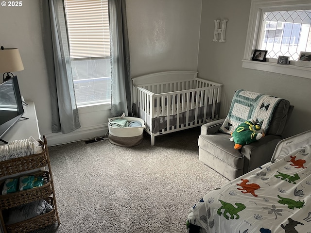 bedroom featuring carpet floors and a nursery area