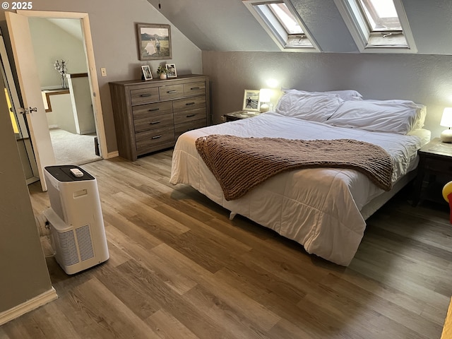 bedroom featuring light hardwood / wood-style floors and vaulted ceiling