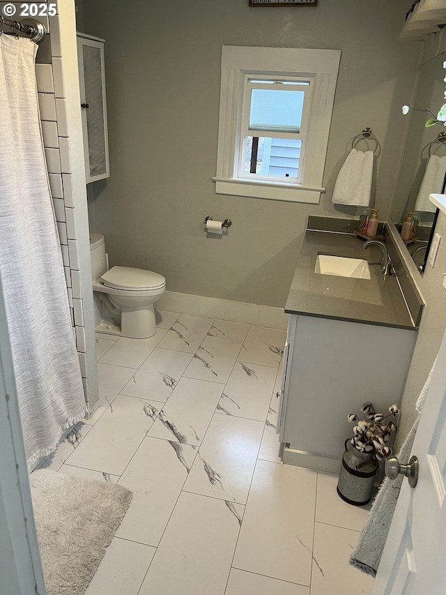 bathroom with curtained shower, vanity, and toilet