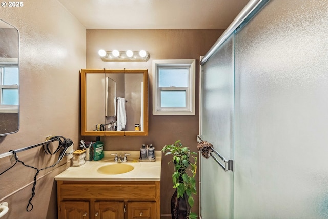 bathroom with vanity, a wealth of natural light, and walk in shower