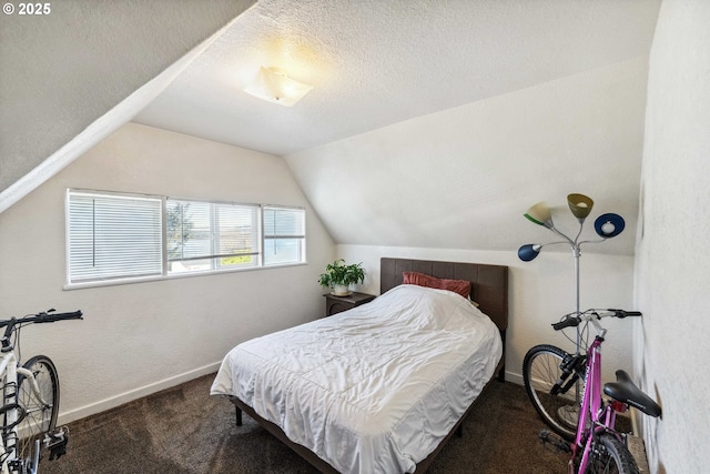 bedroom with dark carpet, vaulted ceiling, and a textured ceiling