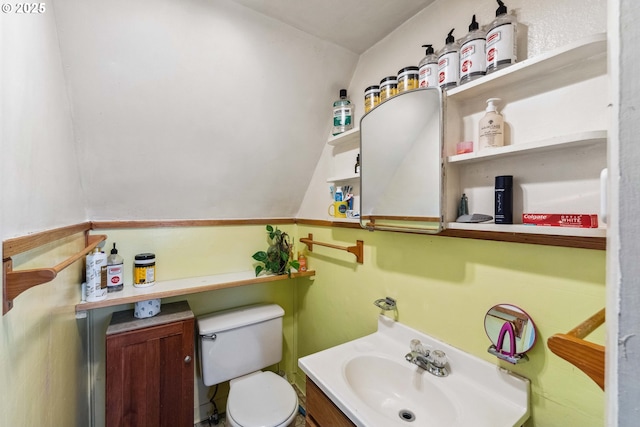 bathroom featuring vanity, lofted ceiling, and toilet