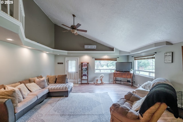 11885 Riverhaven Ln SE, Stayton, OR 97383 - living area with a ceiling fan, wood finished floors, a textured ceiling, high vaulted ceiling, and baseboards