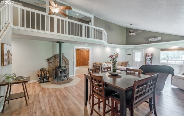 11885 Riverhaven Ln SE, Stayton, OR 97383 - dining room with ceiling fan, high vaulted ceiling, a wood stove, and wood finished floors