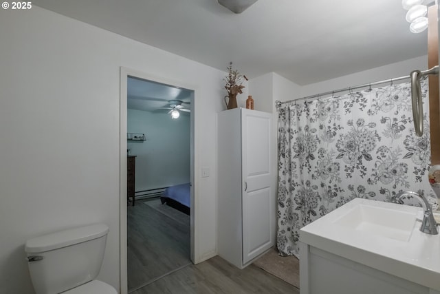 11885 Riverhaven Ln SE, Stayton, OR 97383 - full bathroom with wood finished floors, ceiling fan, toilet, vanity, and a baseboard radiator